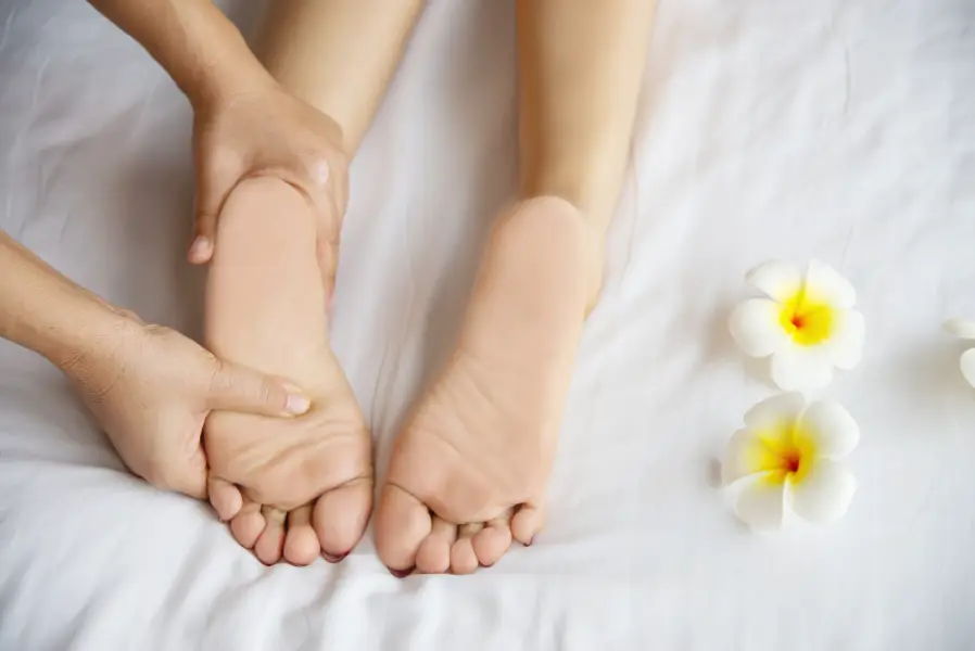 Woman receiving foot massage service from masseuse close up at hand and foot - relax in foot massage therapy service concept